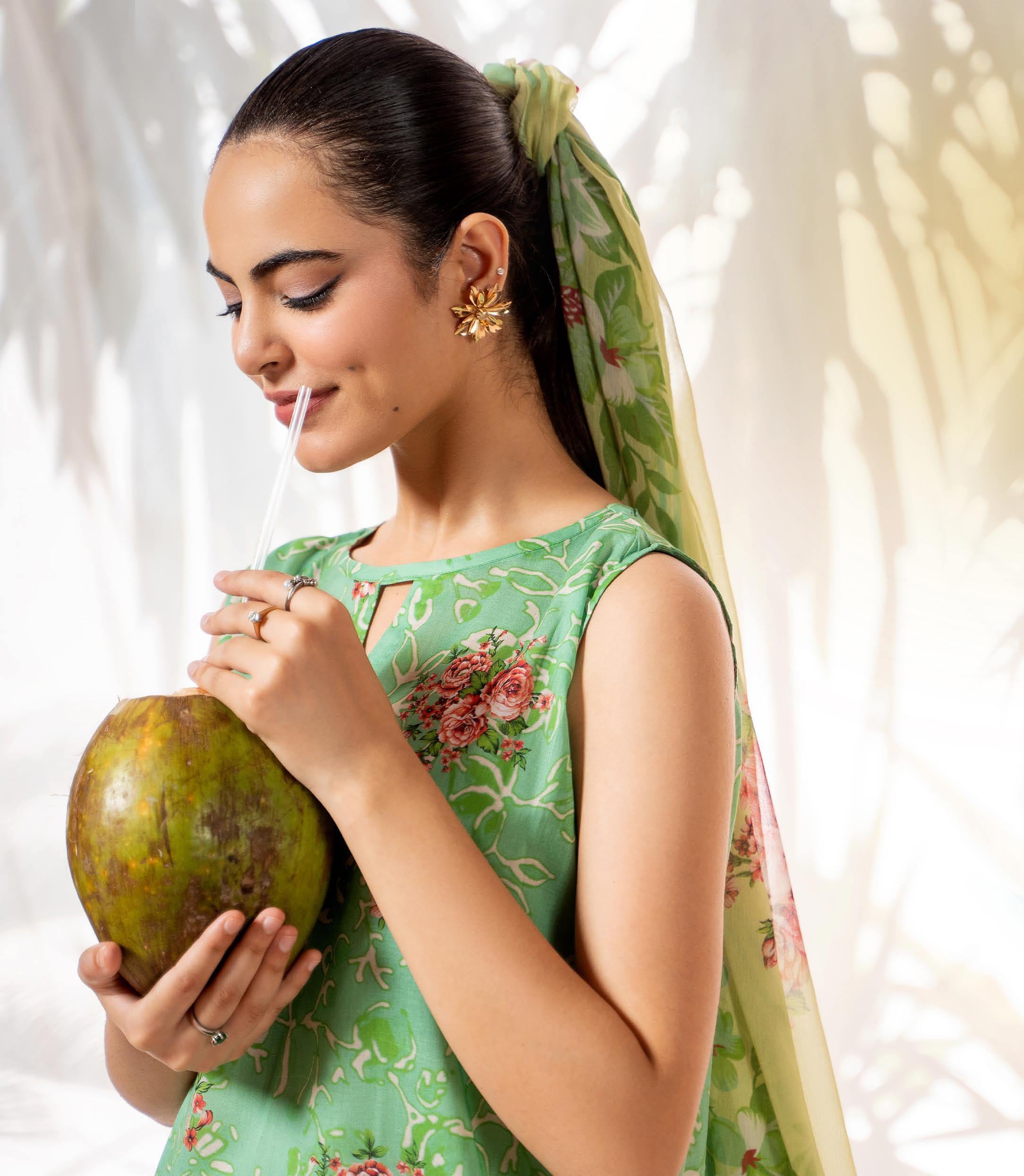 Woman in a green traditional outfit holding a mango with a blurred background and 'oh! The New Look' text.